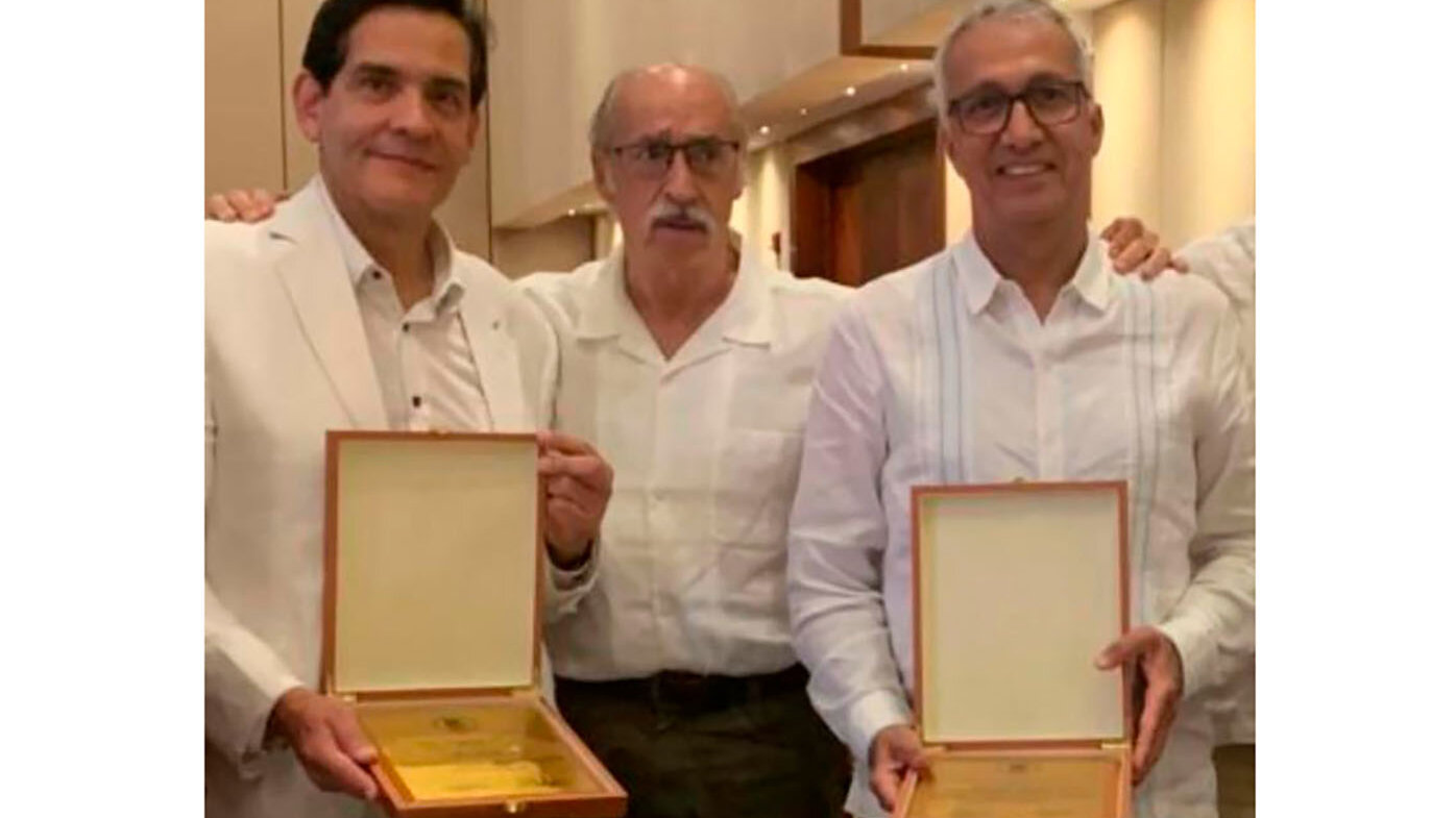 Los doctores Raúl Sastre Cifuentes (izquierda) y Enrique Vergara reciben el reconocimiento de Asocimano por su ardua labor en la especialidad de cirugía de mano en Colombia. 