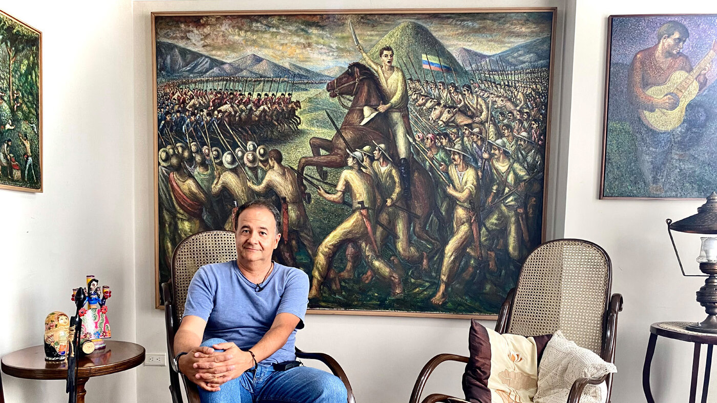 Ricardo Blandón Giraldo y al fondo el mural: Batalla del pantano de Vargas, pintado por Alipio Jaramillo Giraldo. Foto: Natalia López Arboleda, Unimedios Manizales. 